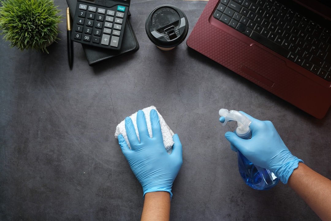 Office Cleaning person-in-blue-long-sleeve-shirt-sitting-beside-black-laptop-computer-9gpkrsbgmc
